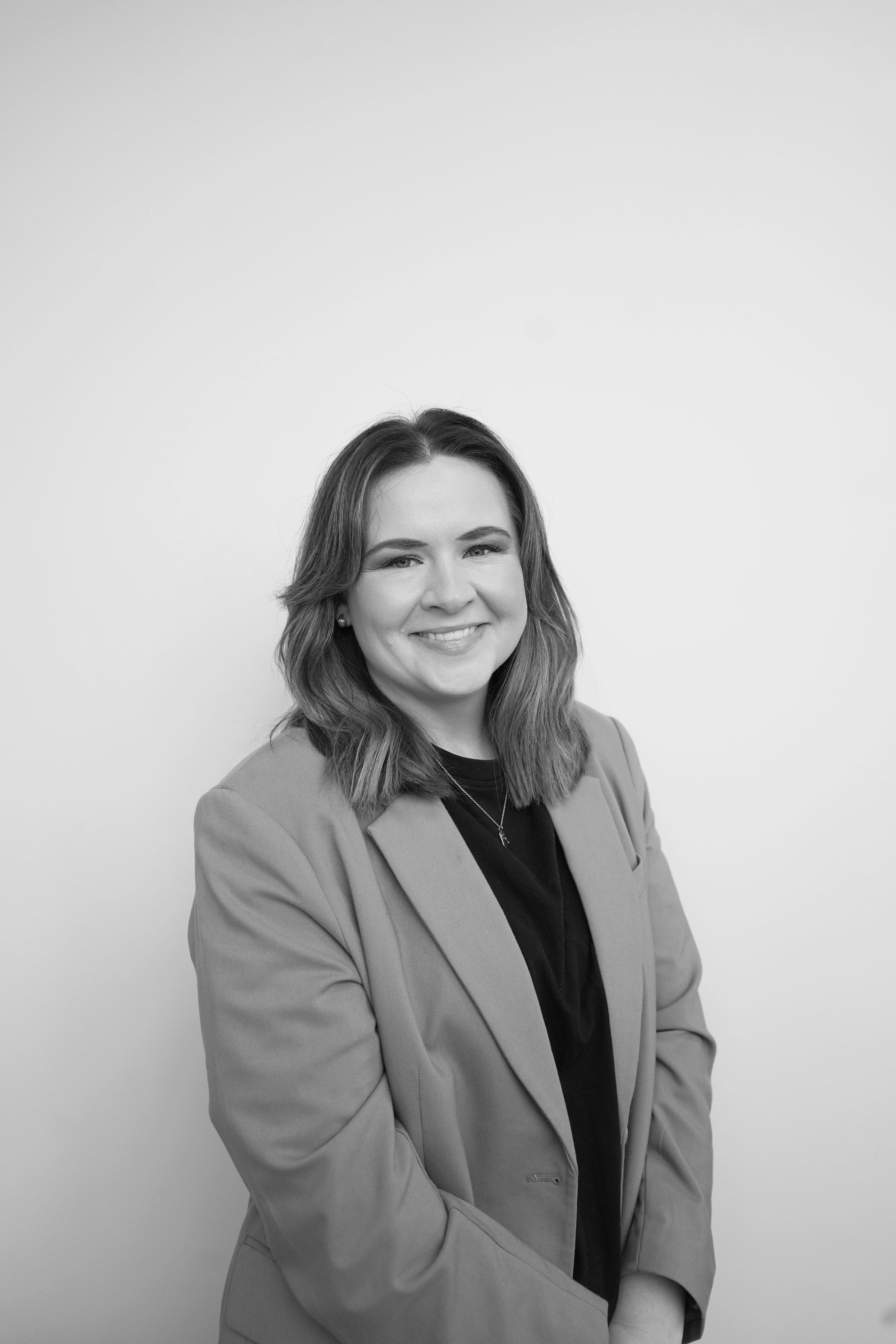 Woman wearing a gray blazer against a white background
