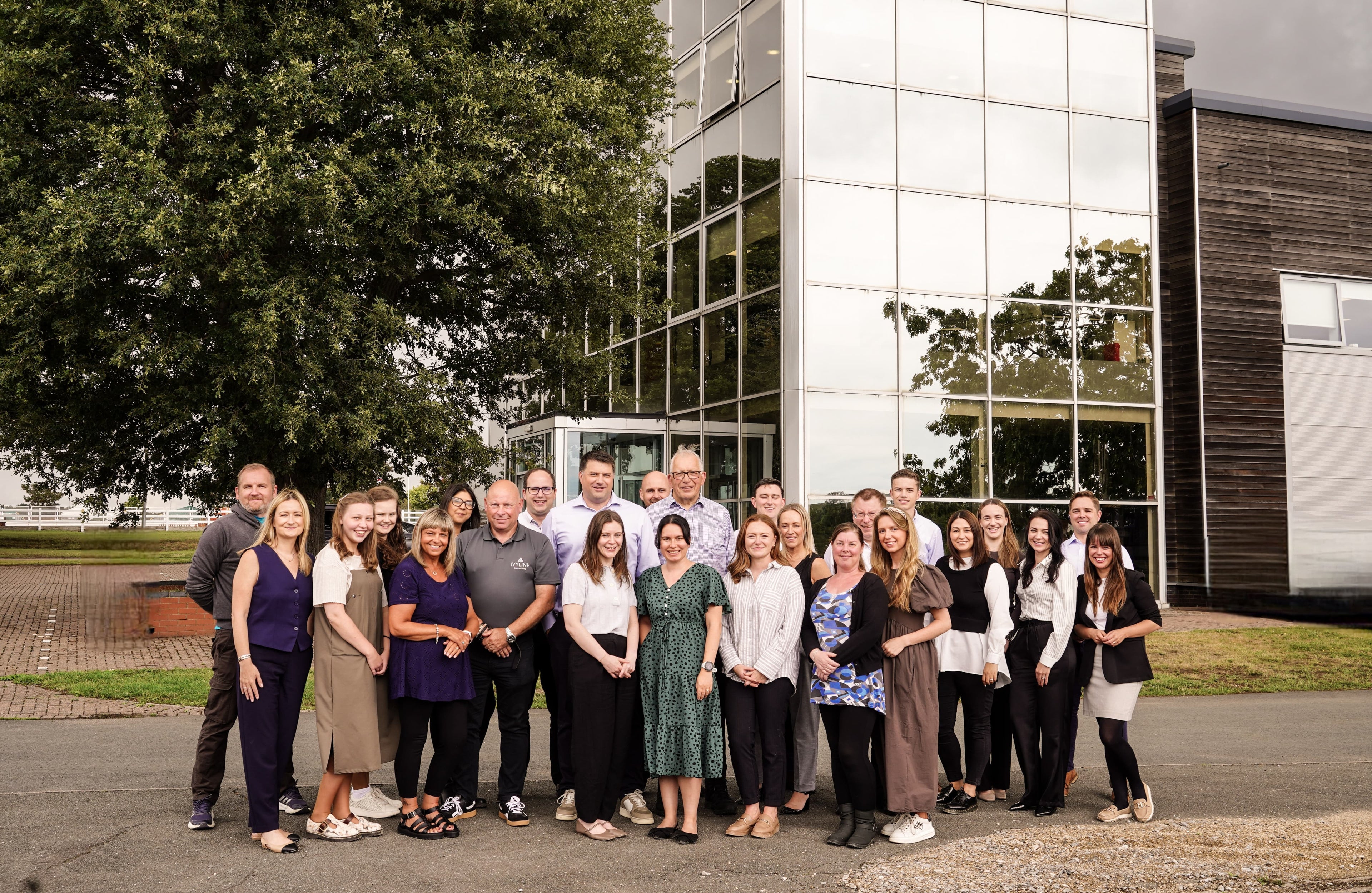 Group of people posing for a photo in front of a modern building.
