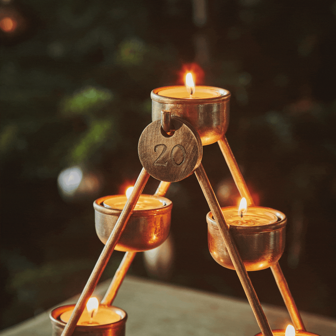 A close up of the date discs counting down from 24 to 20 on the antique brass, Ivyline advent countdown candle holder.